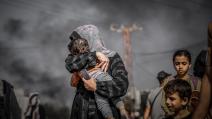 أُم تخبئ وجه طفلها لحمايته، غزة 10 تشرين الثاني/نوفمبر الماضي (Getty)